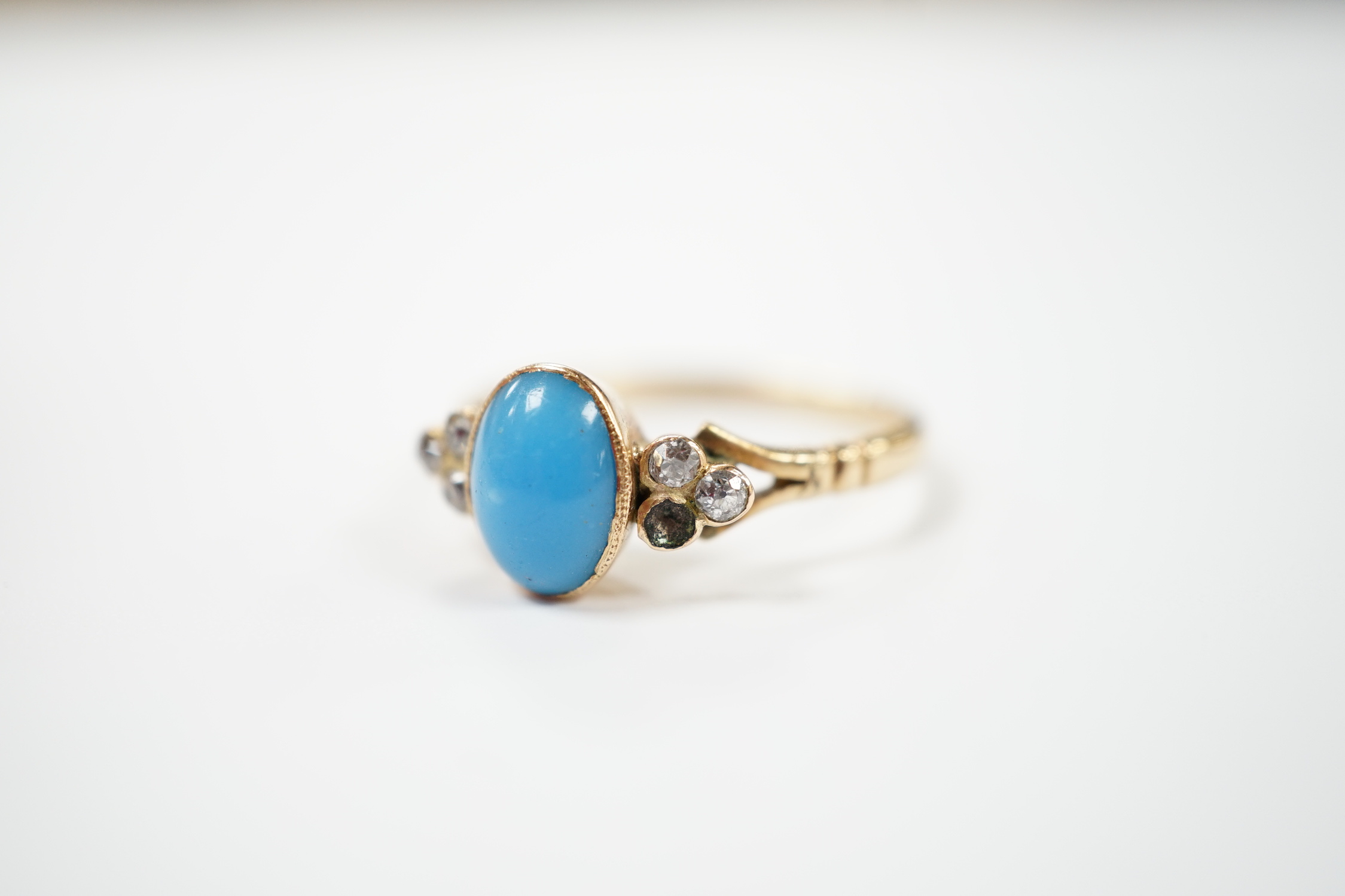 A yellow metal and single stone cabochon turquoise set ring, with six stone diamond set shoulders (stone missing), size S, gross weight 3.9 grams.